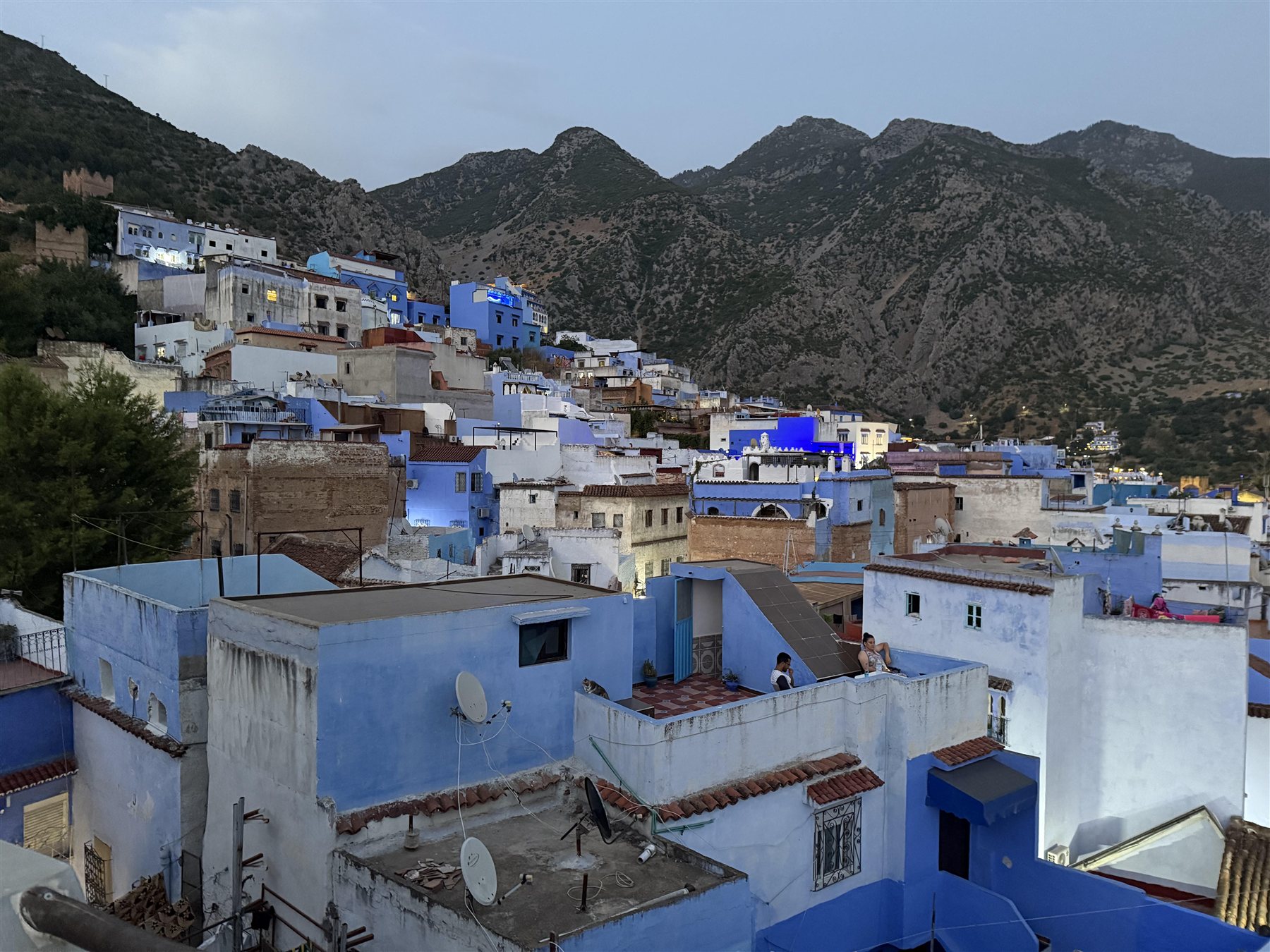 Chefchaouen’s blue rooftops beneath the Rif Mountains at dusk