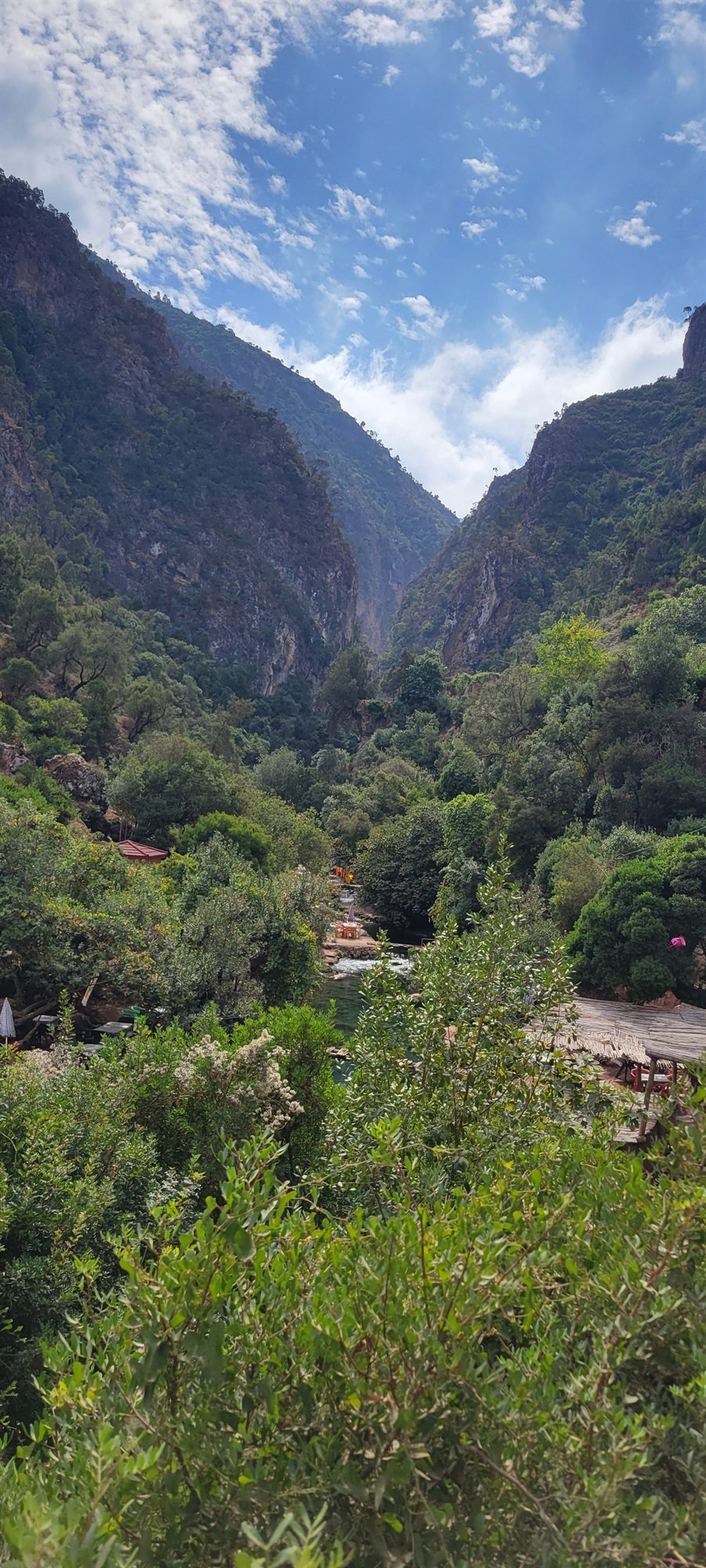 A lush green valley between steep Rif Mountain peaks